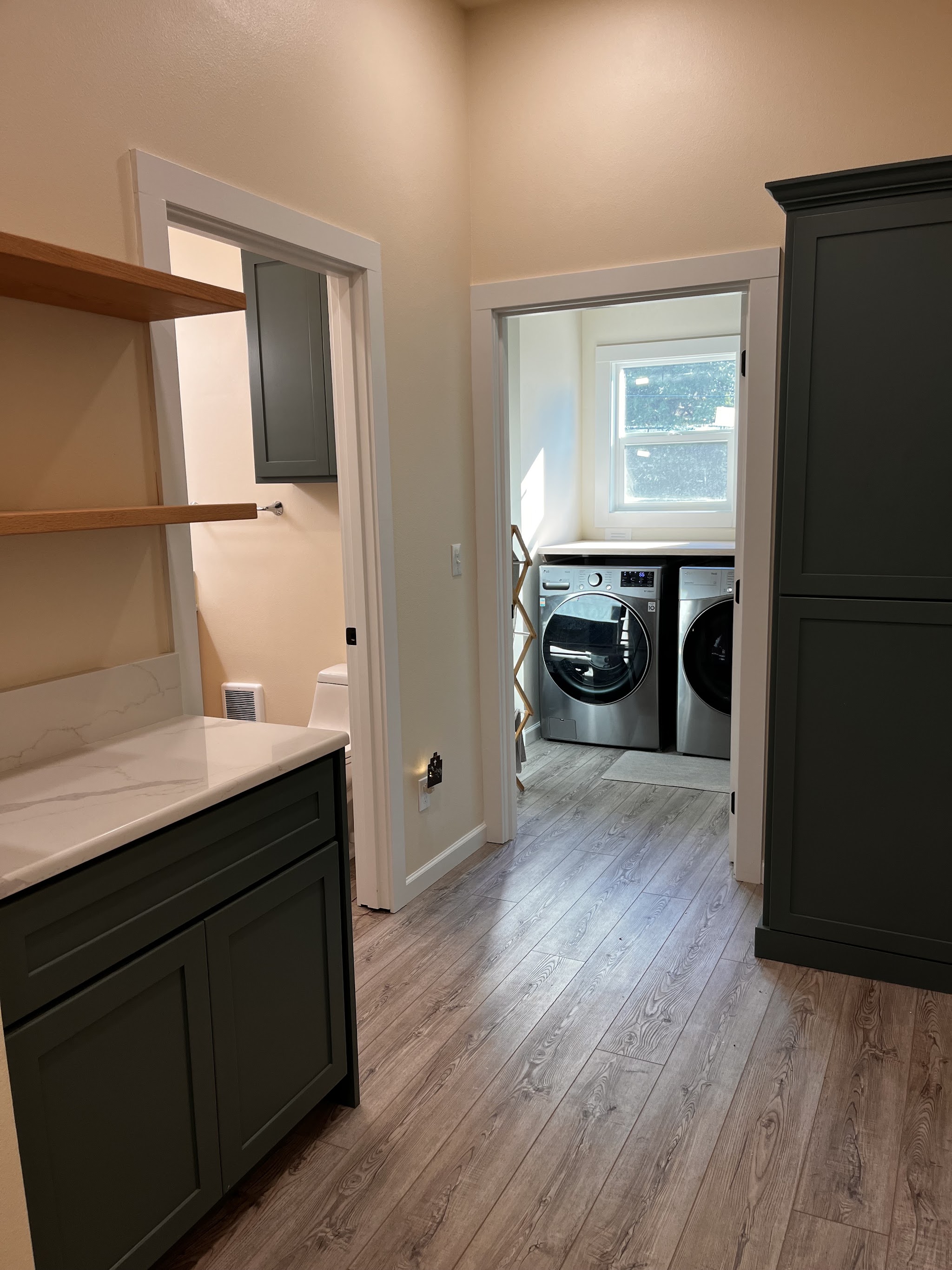 Finished bathroom and laundry remodel with dark cabinetry and marble countertop