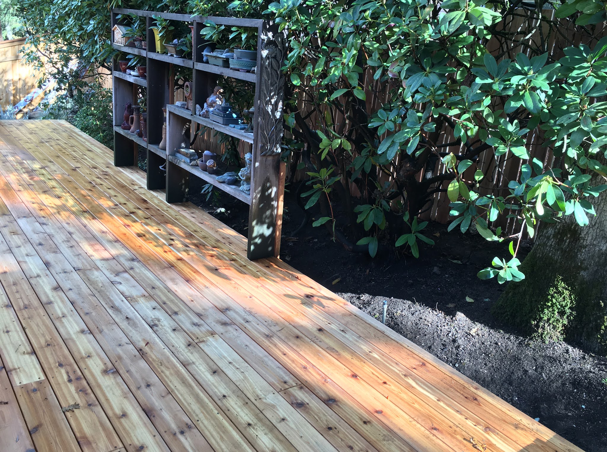 Cedar deck with built-in wood shelving unit along the fence line