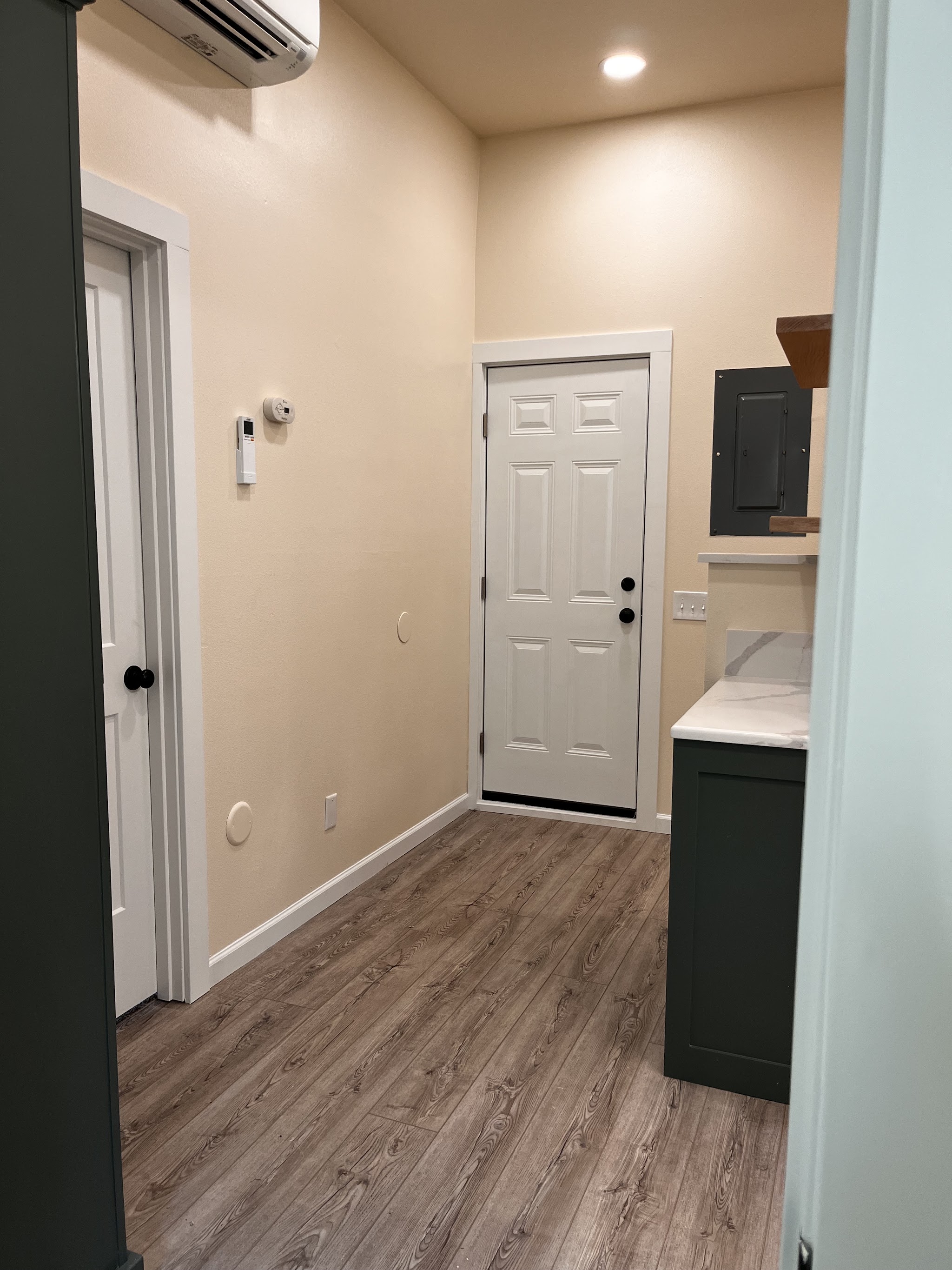 Finished entryway and utility area with painted cabinetry
